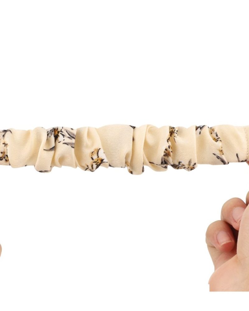 Beige floral elastic scrunchie loop band for Apple Watch stretched between two hands