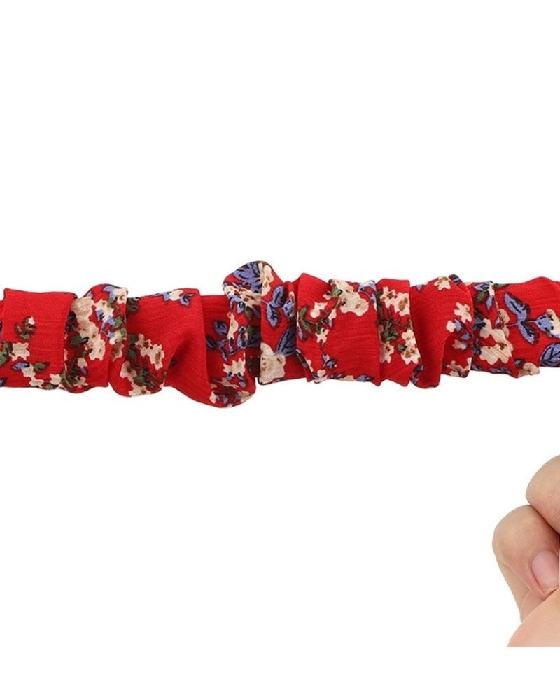 Red floral scrunchie elastic fabric Apple Watch band stretched between two hands