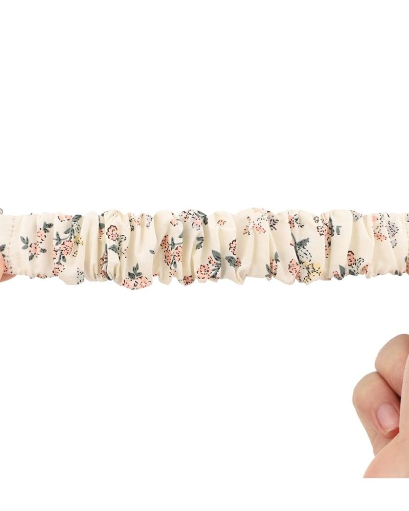 White floral scrunchie loop band for Apple Watch stretched between two hands