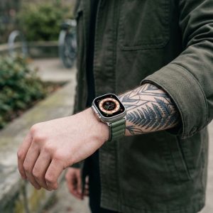 Model wearing Alpine Loop Band For Apple Watch in Green Apple Watch band
