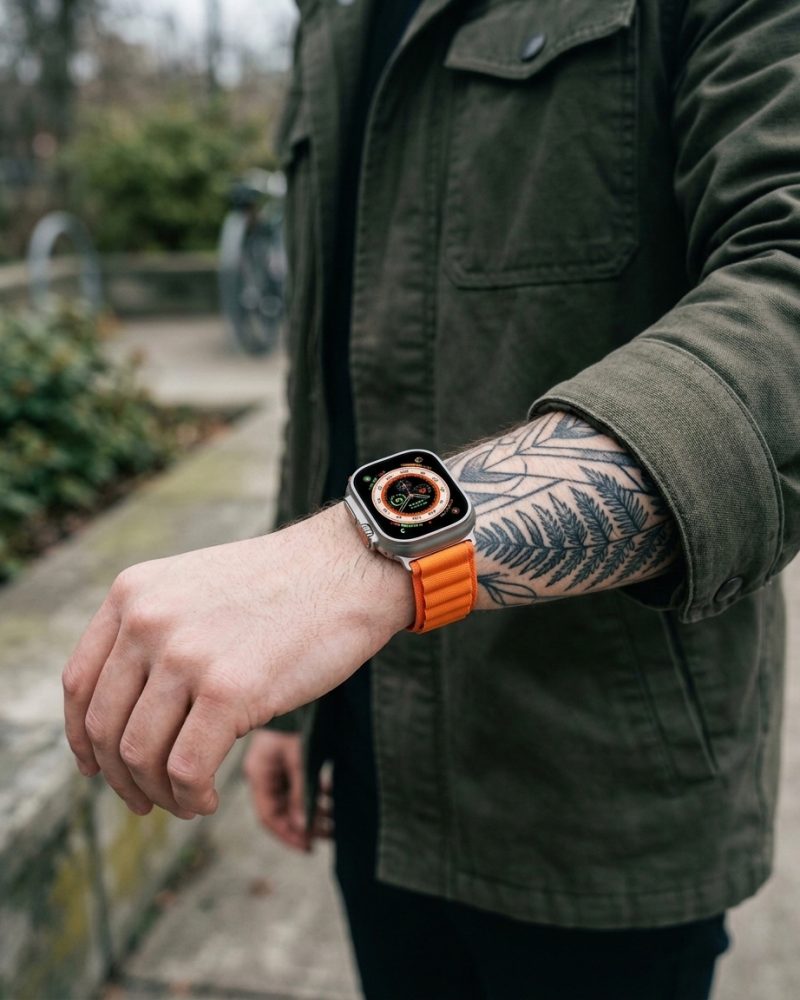 Model wearing Alpine Loop Band For Apple Watch in Orange Apple Watch band