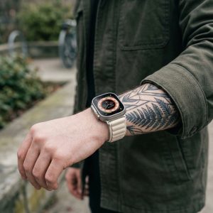 Model wearing Alpine Loop Band For Apple Watch in Starlight Apple Watch band